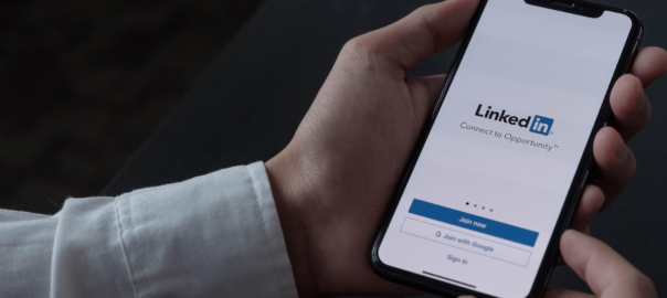 Osoba trzymająca telefon na którym jest linkedin