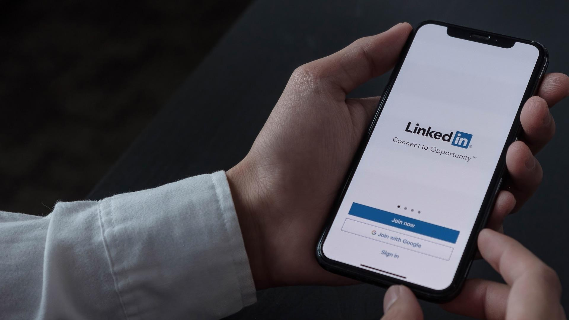 Osoba trzymająca telefon na którym jest linkedin